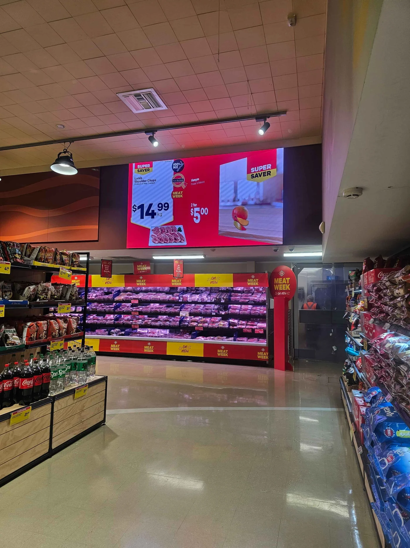 Digital signage displaying fresh offers above the meat department in a New World store